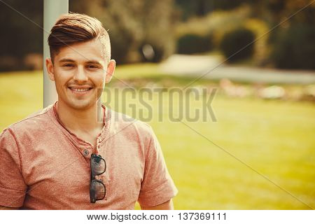 Handsome masculinity relax concept. Smiling boy enjoying park. Young relaxed man outdoors.