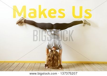 Fit woman doing a handstand near the wall below the phrase 