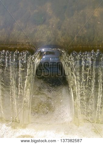Small waterfall in brook foaming from surface-active agents