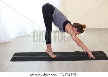 Slim and sporty woman practice Yoga in a training hall background. Healthy lifestyles concept