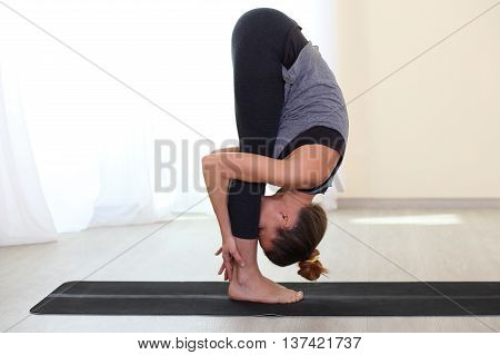 Slim and sporty woman practice Yoga in a training hall background. Healthy lifestyles concept