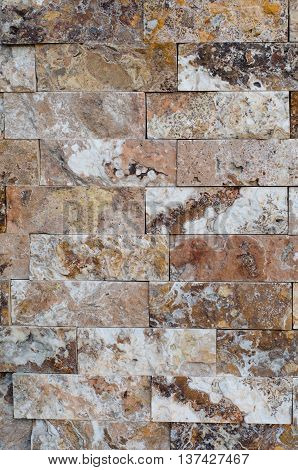 Background of a stone wall cladding texture brown stone bricks
