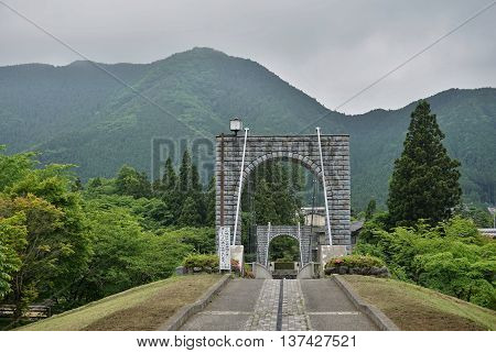Majestic cable stony bridge for pedestrians spanning over the green valley in Nikko, Japan