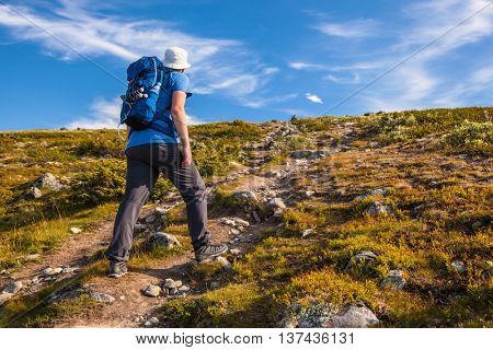 hiker with backpack traveling in Norway mountains Dovre