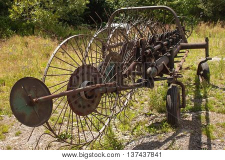 Old rusty Hay Turner.  Old agricultural equipment on hay.