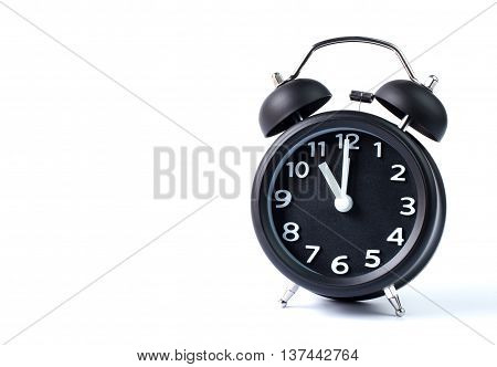 Black double bell alarm clock showing eleven o'clock on white background