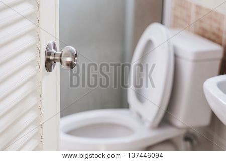 Close up, toilet door opening, with stationery ware, selective focus on door knob