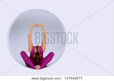 sporty woman in active wear practicing yoga exercises in geometric design of round shapesin sphere. Studio shot white background. Creative concept sports.