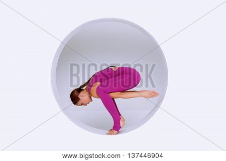 Beautiful and slim woman active wear practicing yoga exercises in geometric design of round shapesin sphere. Creative concept sports on white background. Empty space text