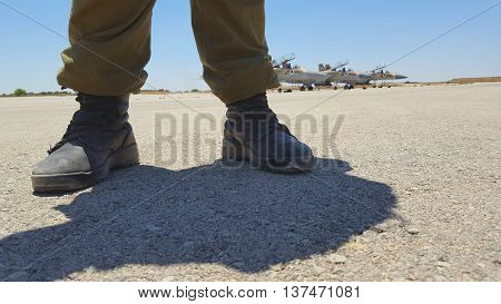 feet of a soldier on a three airplanes background