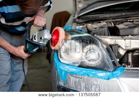 Mechanic Cleaning Headlights And Polishing With Power Buffer Mac