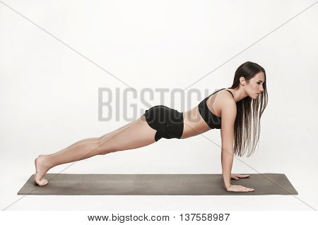 Portrait of young attractive woman doing exercises. Brunette with fit body on yoga mat. Healthy lifestyle and sports concept. Series of exercise poses.