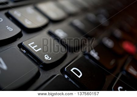 Detail of a brand new modern black laptop keyboard with the focus on the key with Euro currency(€) symbol