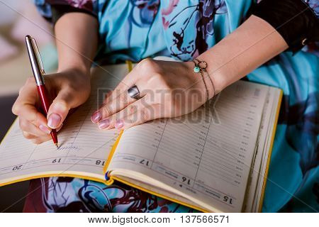 respectable woman is writing notes and planning schedule. closeup beautiful hand writing notes