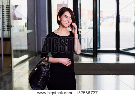 Attractive business lady in Shopping Mall emotionally talking on the phone. woman laughs.