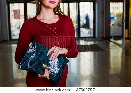 Lady's bag. Closeup of green leather handbag in hand of modern woman. fashion accessory. Elegant clothes.