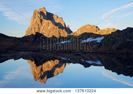 Midi Dossau Peak reflected in a lake. Ossau Valley, Pyrenees National Park, Pyrenees, France.
