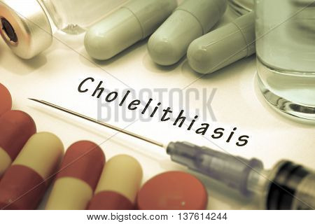 Cholelithiasis - diagnosis written on a white piece of paper. Syringe and vaccine with drugs.