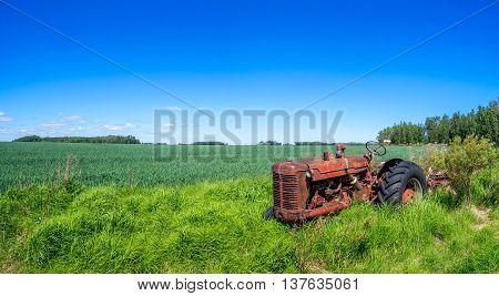 SASKATCHEWAN, CANADA - JUNE 30: An abandoned tractor on June 30, 2016 in field in Saskatchewan, Canada. Saskatchewan is a major agricultural producer in Canada.