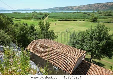 Sas Lake rural scene with back yard field and reedbed, Montenegro