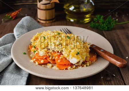 Oven-roasted fish fillet with carrots under a bread crust. For garnish white rice