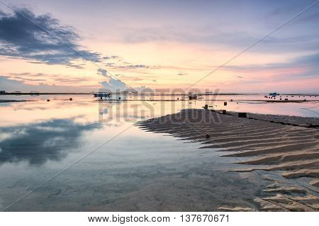Holiday in Bali, Indonesia - Reflection Sunrise in Tanjong Benoa with boat