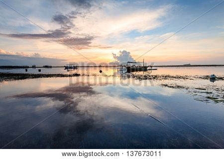 Holiday in Bali, Indonesia - Reflection Sunrise in Tanjong Benoa with boat