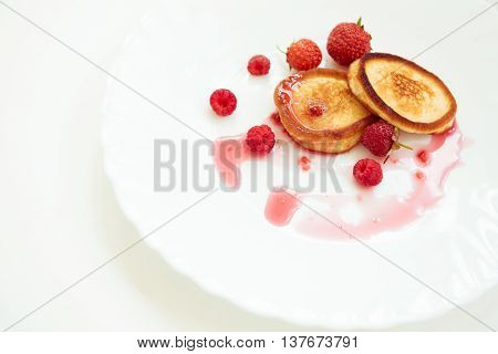 Pancakes on the white plate with raspberry jam