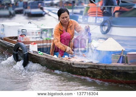 Woman Cooking In The Floating Market In Can Tho