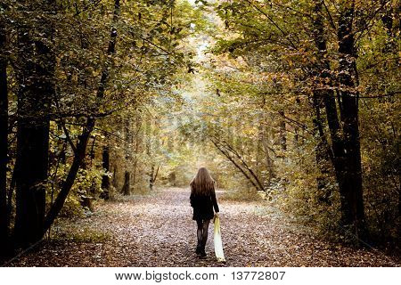 Mujer triste caminando sola por el bosque