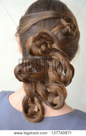 Weaving with long hair - young girl in blue on a white background
