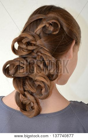 Weaving with long hair - young girl in blue on a white background