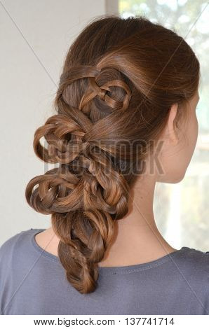 Weaving with long hair - young girl in blue on a white background