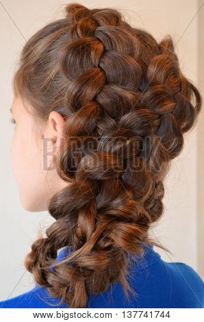 Weaving with long hair - young girl in blue on a white background