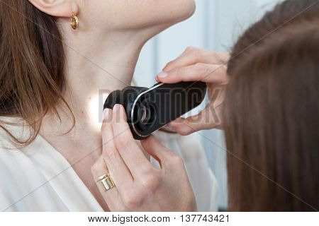 Doctor examining birthmarks and moles on a female patient (examination of birthmarks)