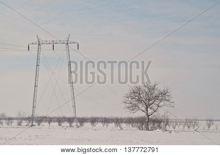 High voltage electric pole in gloomy winter day