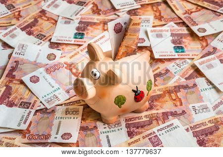 Piggy Bank In A Pile Of Russian Five Thousand Banknotes