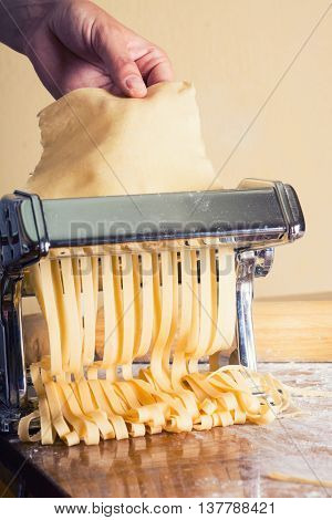 fresh pasta and pasta machine on kitchen table