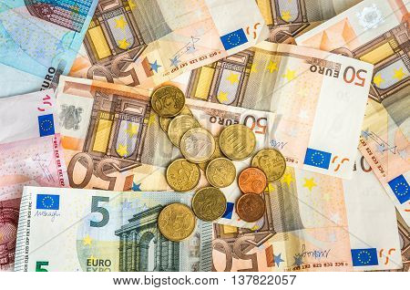Euro Banknotes And Coins Scattered Over The Table