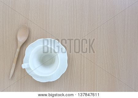 White coffice cup and wooden spoon in top view on wood background for design concept food.