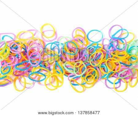 Surface covered with multiple colorful resin loom bands over the white background