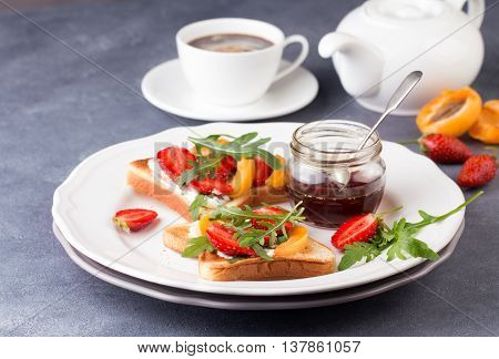 French toast with fresh strawberries, peaches and arugula, poured with maple syrup