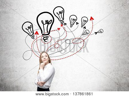 Different direction and idea concept with thoughtful businesswoman lightbulb and arrow sketches on concrete background