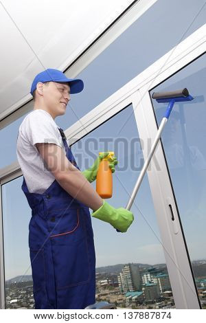 Professional cleaning. Young man washes window