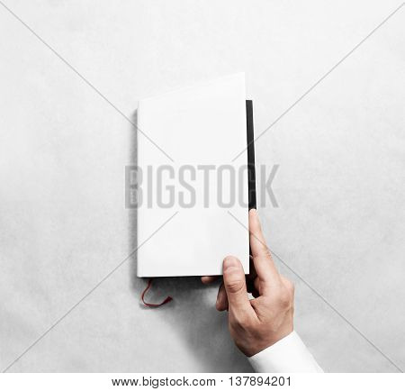Hand opening blank white book cover mockup template. Clear booklet front surface design mock up. Arm holding opened textbook diary. Reading clean notebook copy. Closed catalogue presentation display.