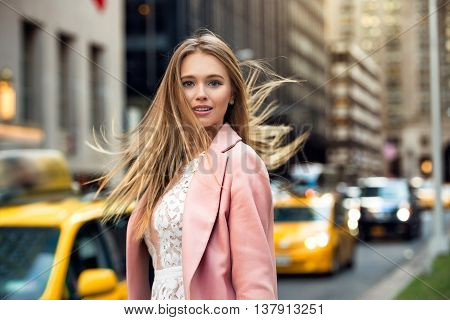 Portrait of the blonde with flyaway hair in the background of New York City street with taxi cabs