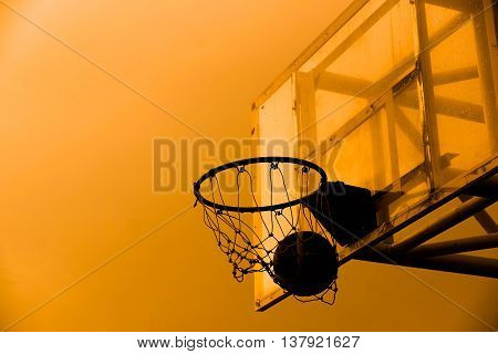 Basketball in a net silhouette. Basketball with sunset silhouette background
