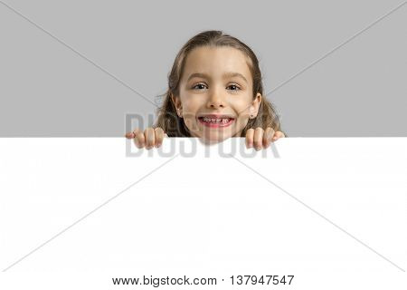 Cute little girl holding a blankboard, with copy space