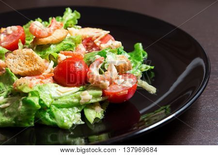 Caesar Salad with Shrimp on a black plate