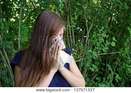 young woman blowing her nose with paper tissue